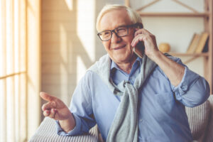 Old man on the phone hears good news from his doctor