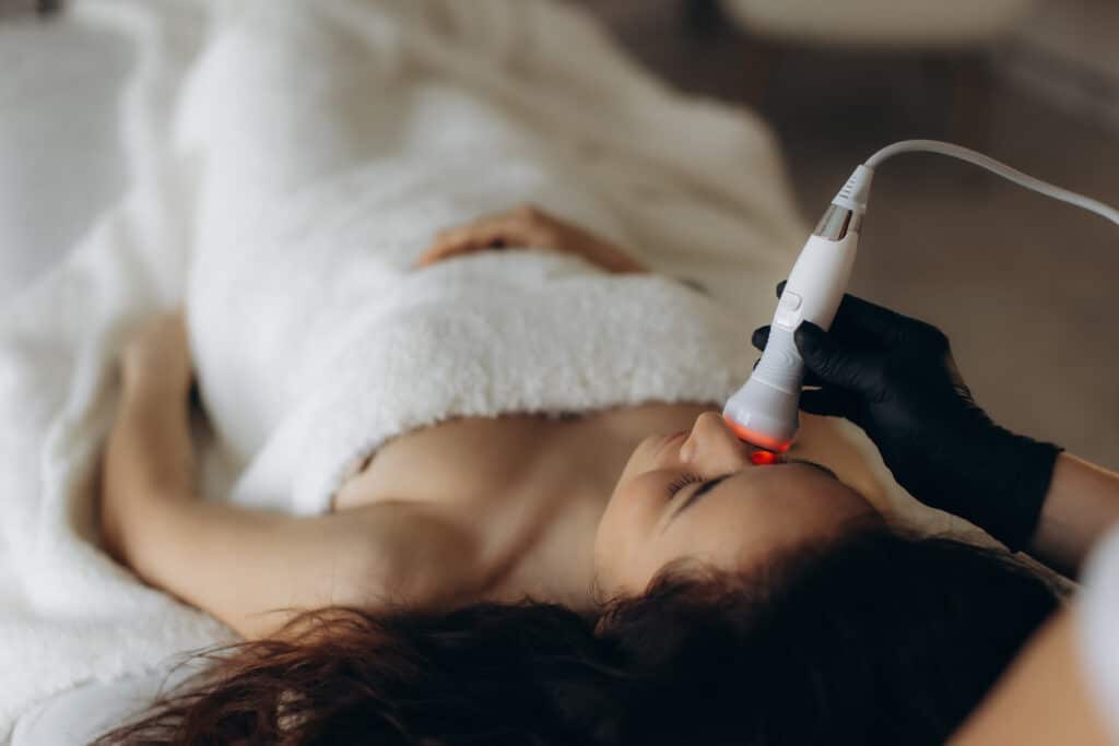 Woman receiving skincare laser facial treatment in beauty clinic. RF face lifting iStock 2274762339